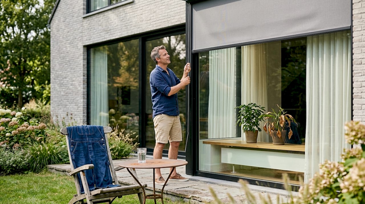 Een eigentijdse woning met een man op het terras en stijlvolle zonwering.