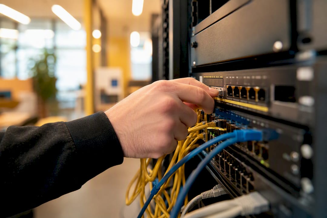 Hand som justerar kablar i serverrack