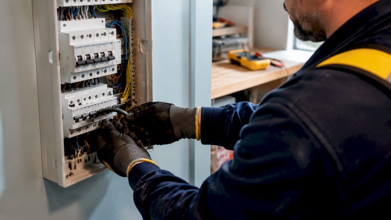 Tableau électrique équipé de disjoncteurs, intervention d’un électricien en cours