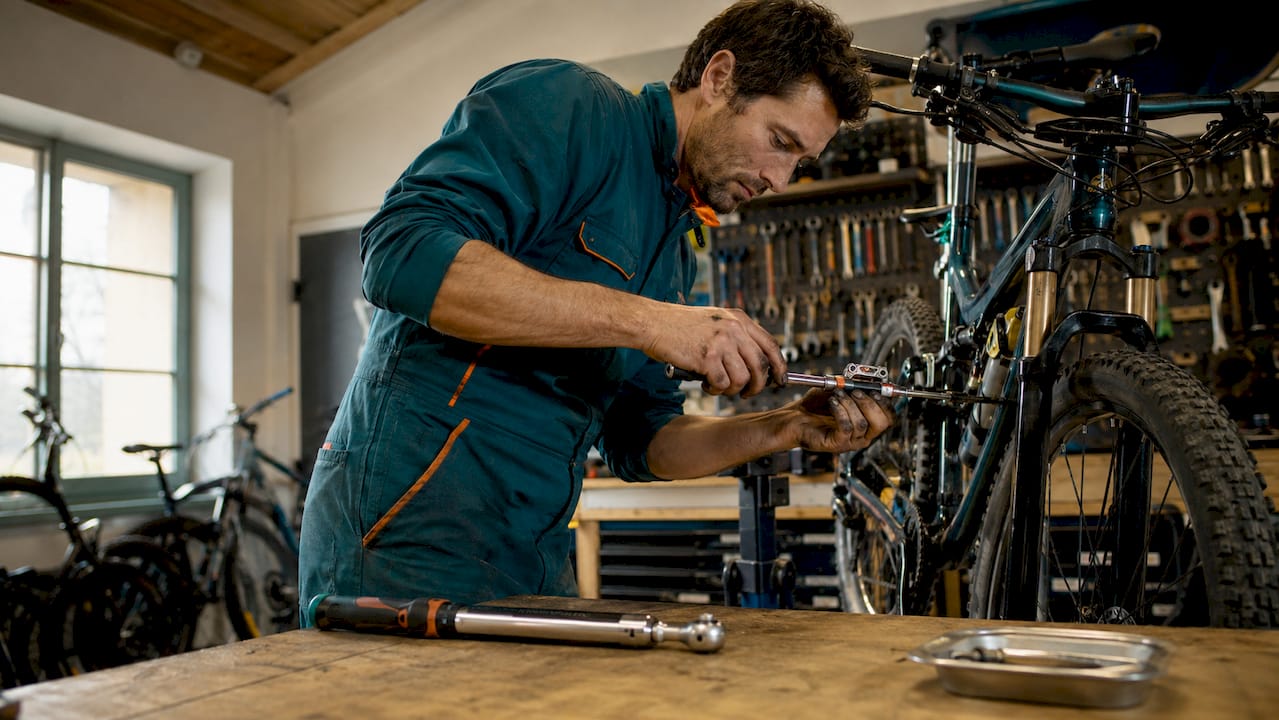 Un spécialiste de la mécanique vélo en plein réglage du dérailleur