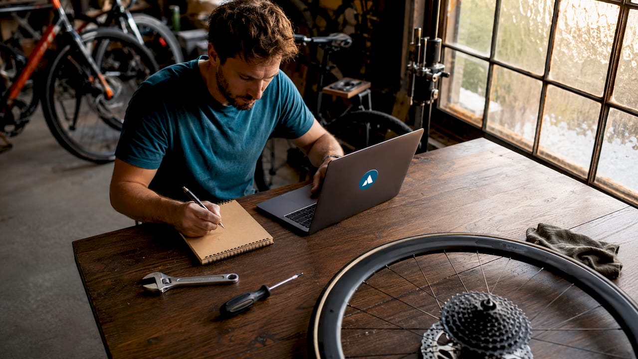 Un technicien cycle travaillant en atelier et utilisant un logiciel professionnel dédié à la réparation et à l’entretien des vélos.