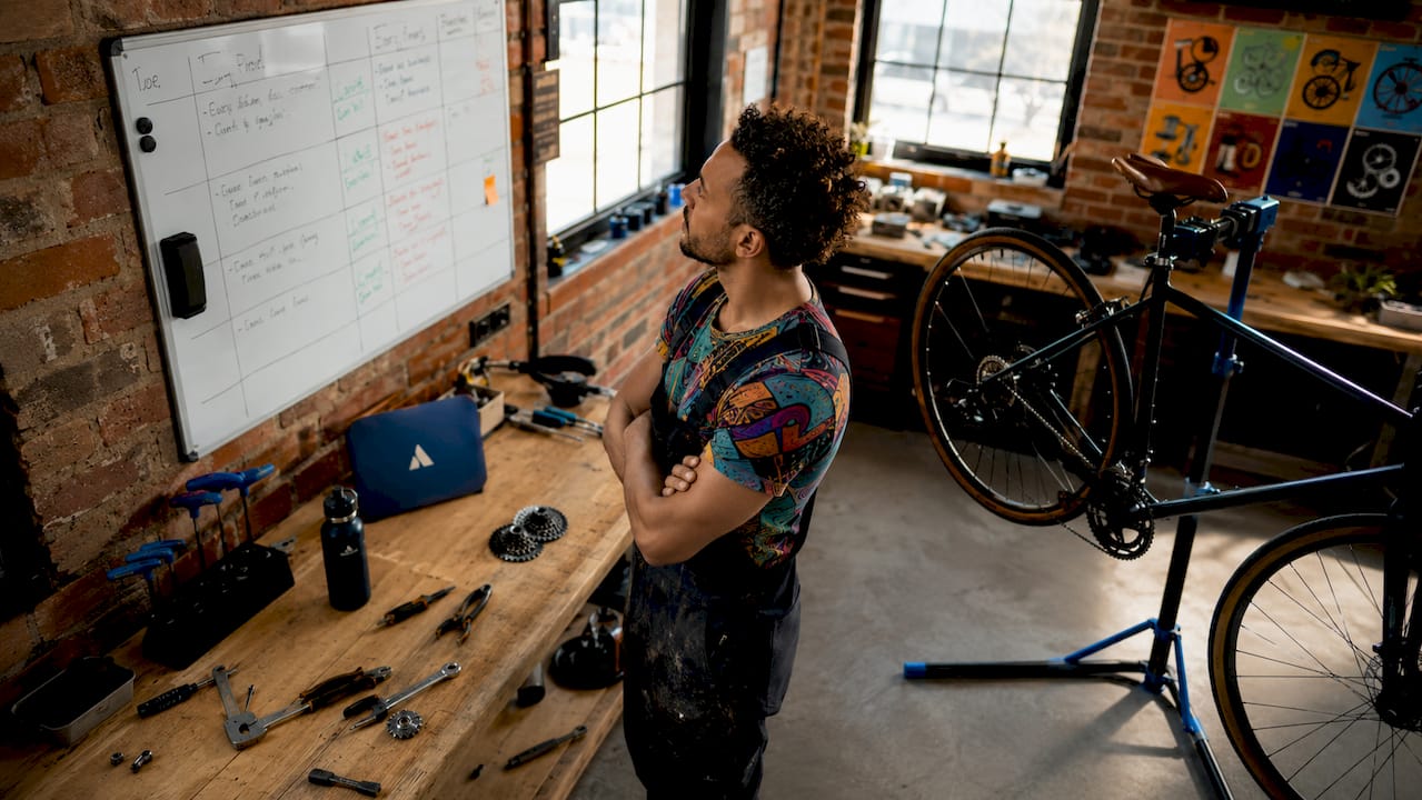 Un mécanicien vélo organise son planning de réparations à son bureau, prêt à prendre en charge les prochains vélos à remettre en état.