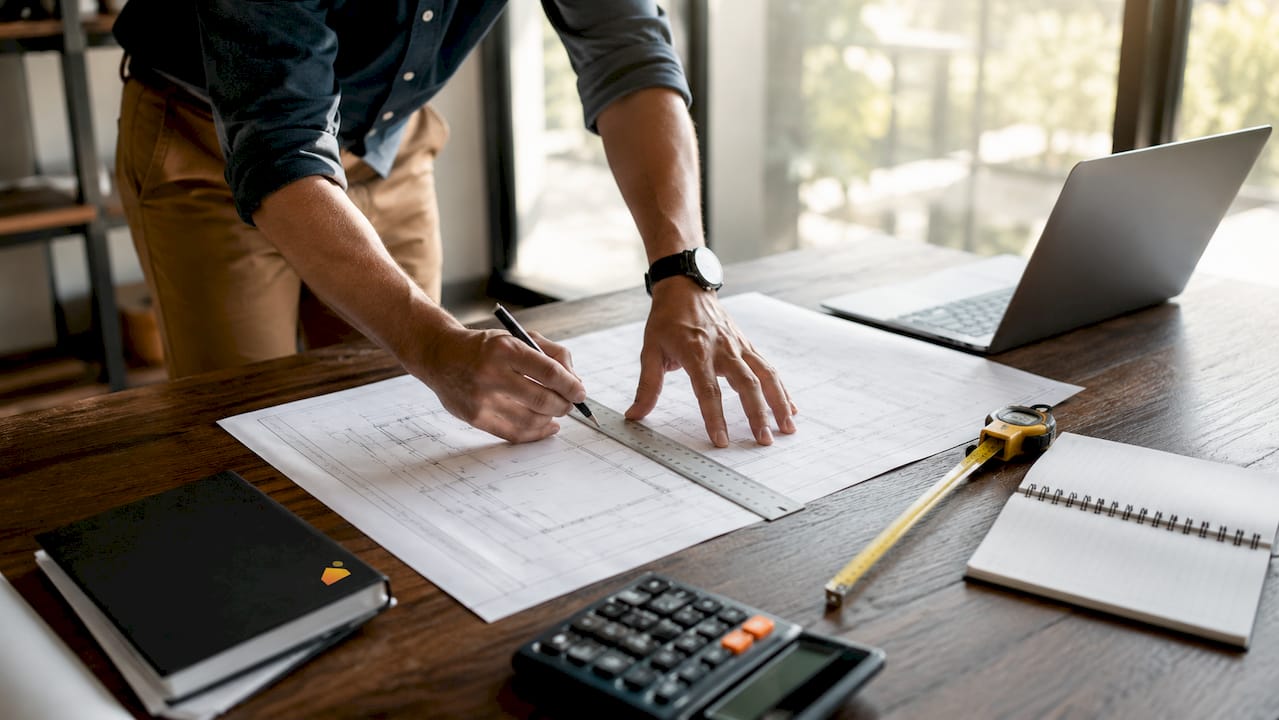 Expert réalisant le relevé de la hauteur sous plafond à partir des plans