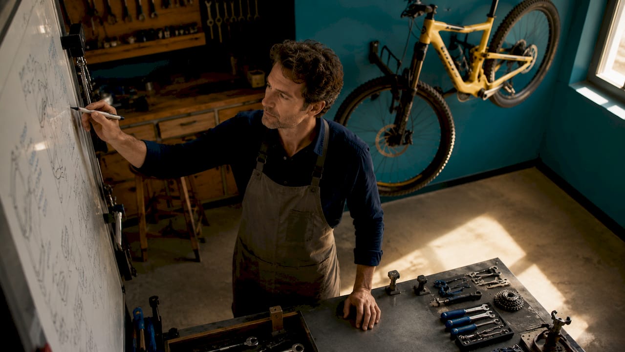 Un technicien cycle en atelier qui prend note des demandes d’un client
