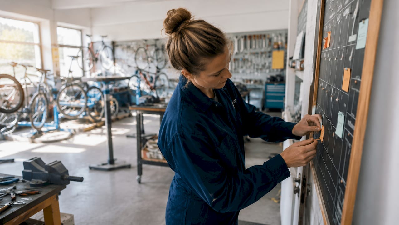 La technicienne réorganise le planning de l’atelier vélo pour optimiser les interventions.