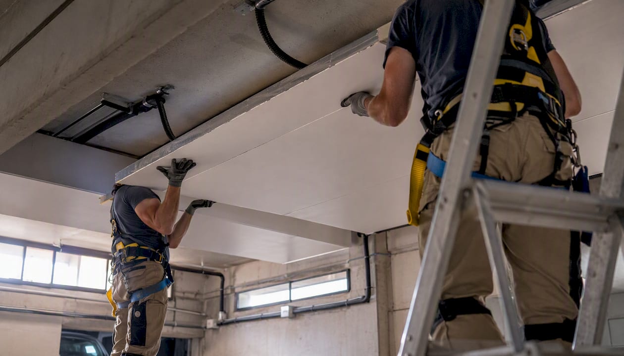 Des panneaux isolants sont en cours de pose au plafond du parking.