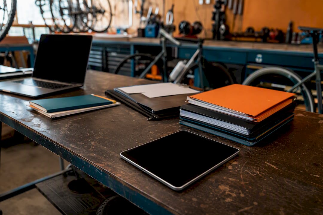 Un espace de travail organisé avec un ordinateur portable et des dossiers à portée de main.