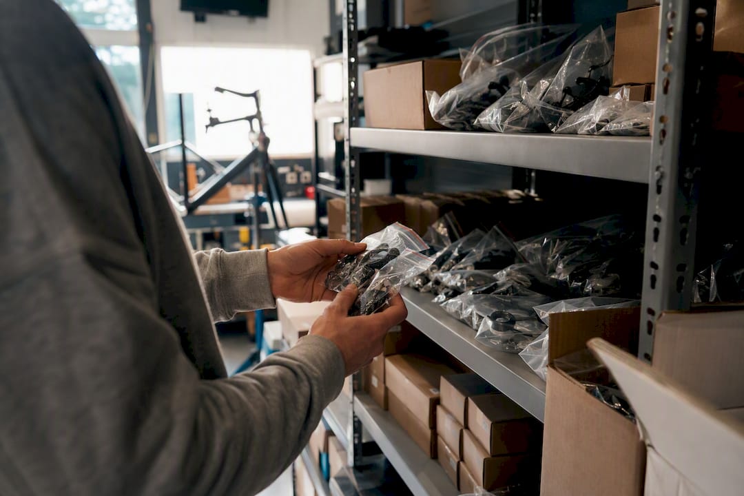 Technicien comptant des pièces de vélo sur l'étagère