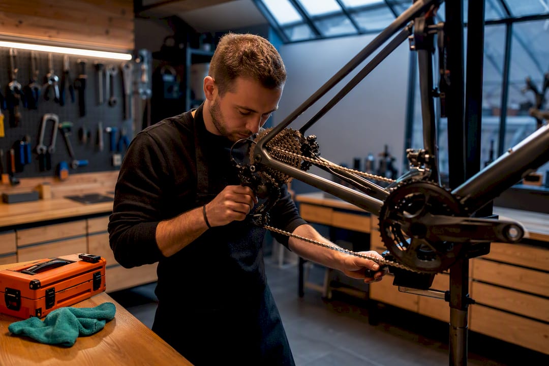 Mécanicien vérifiant la transmission d’un vélo