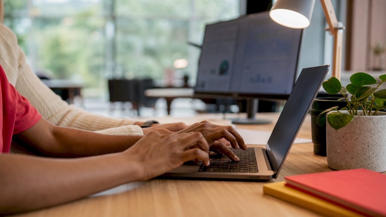 Close-up of hands typing SEO content