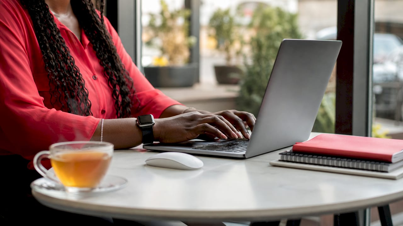 Overhead hands typing on laptop keyboard