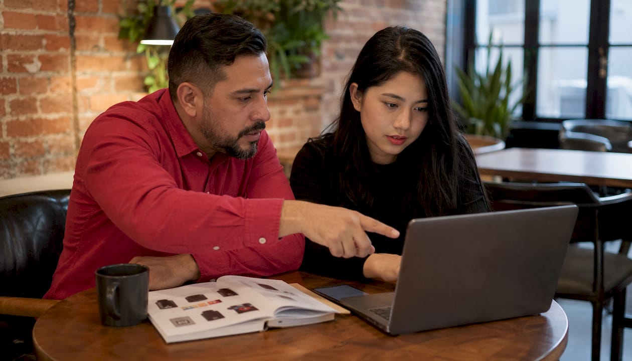 Colleagues discussing configurable product import on laptop