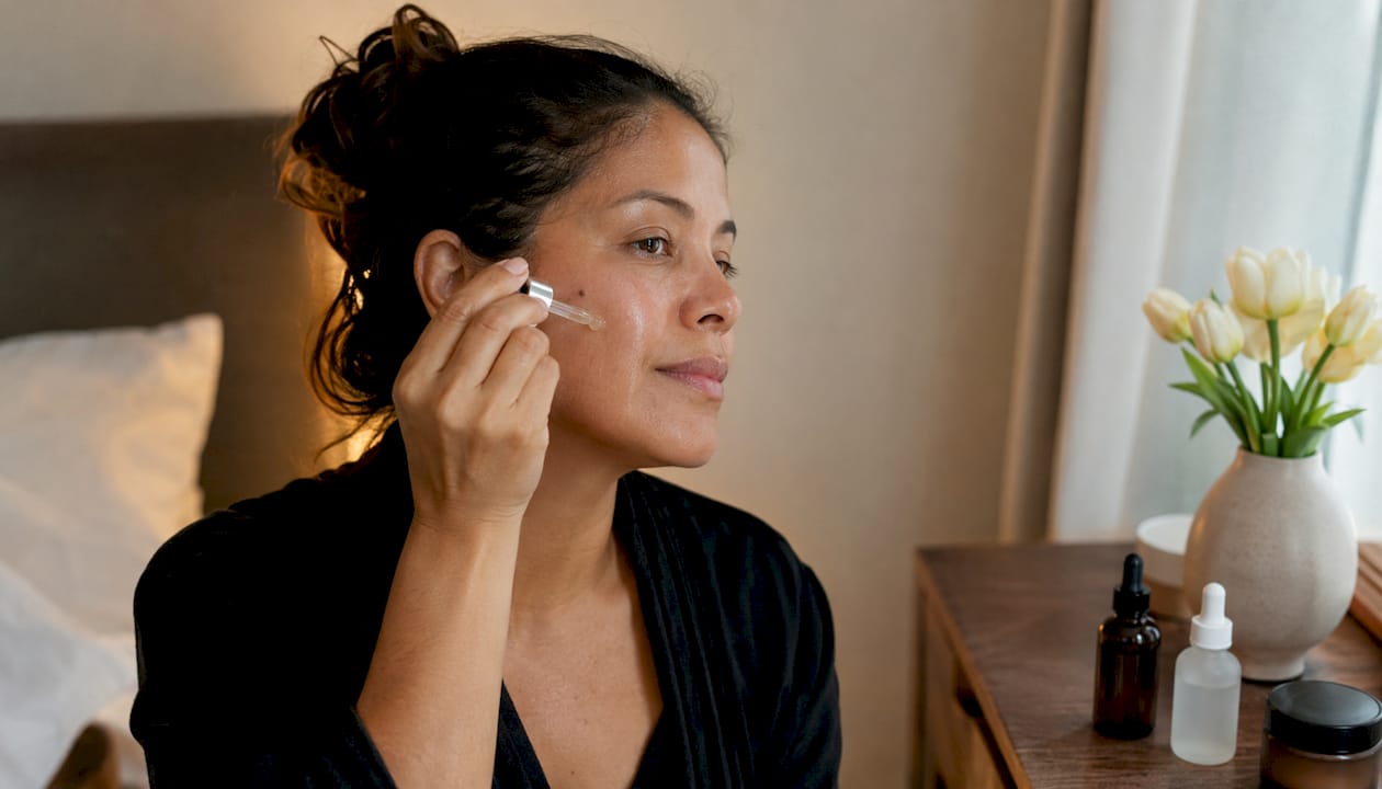 Woman admiring rejuvenated skin at home