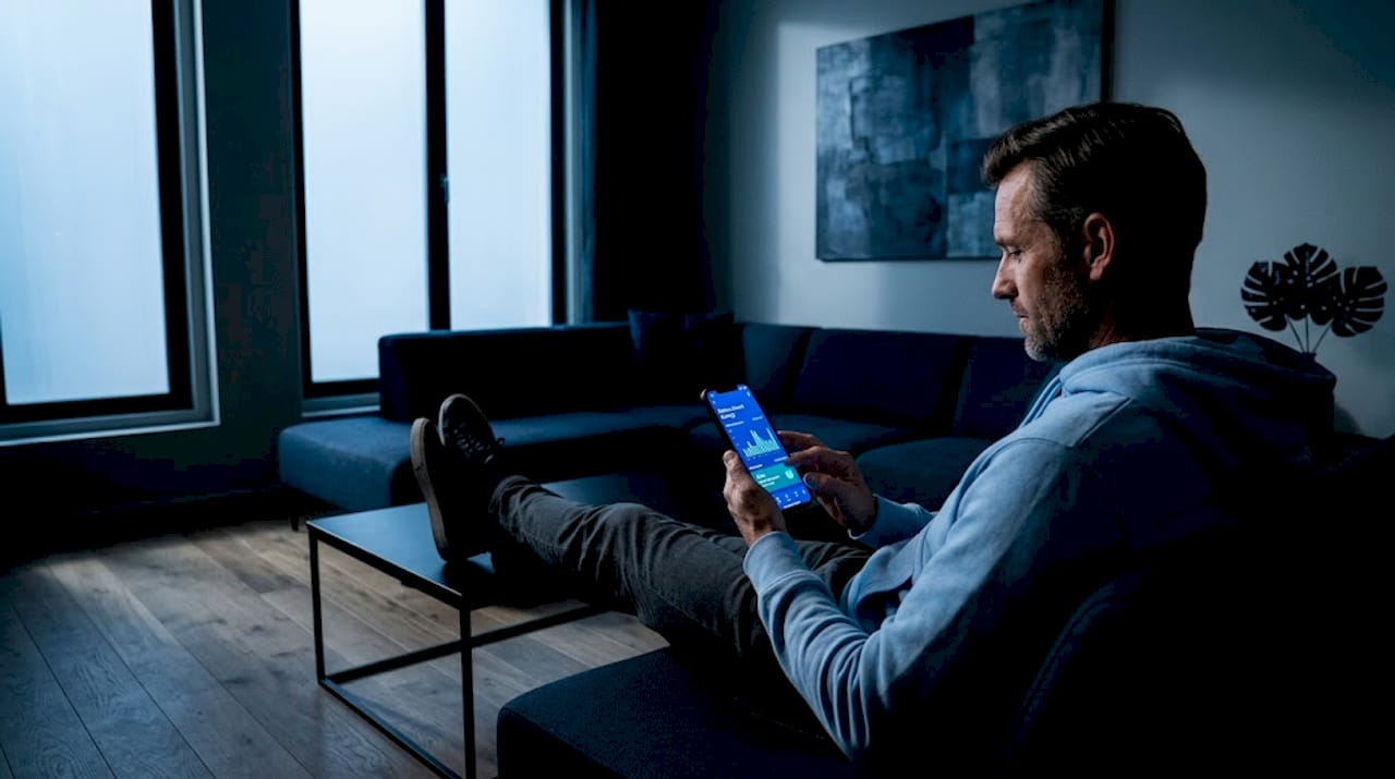 Man using mobile energy app in living room