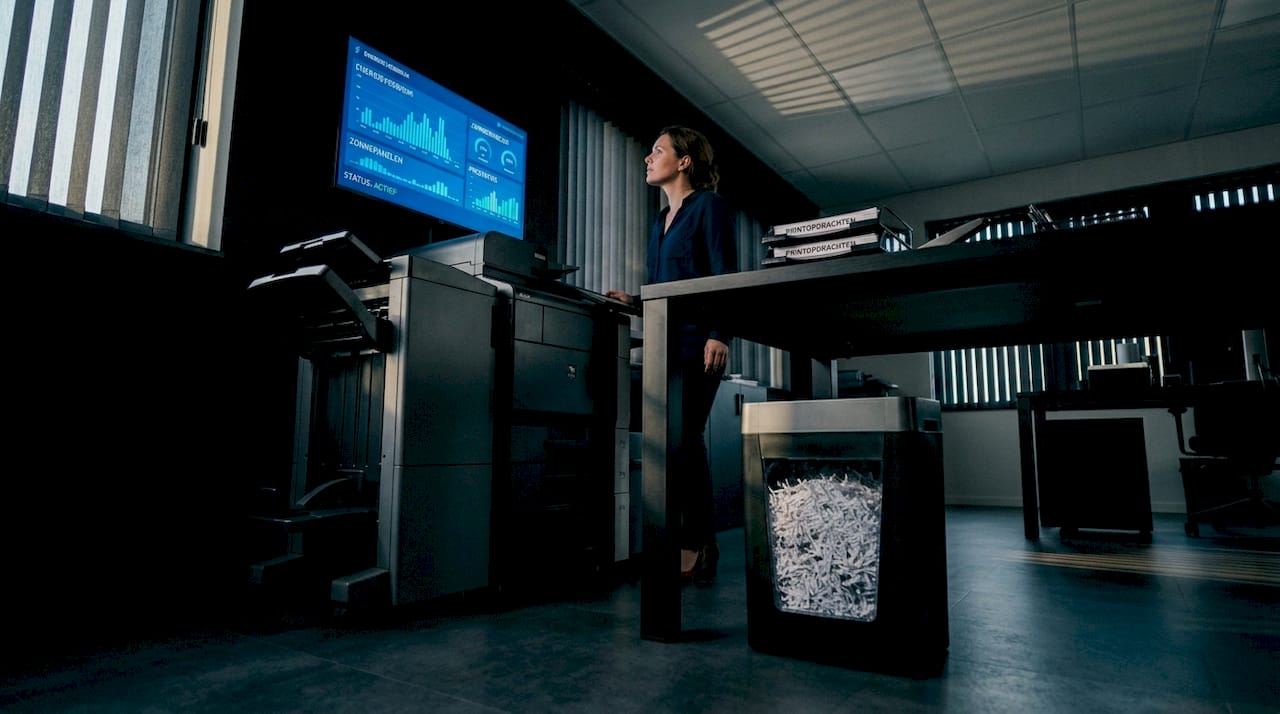 Een vrouw houdt het energieverbruik van haar bedrijf in de gaten via een realtime monitor.