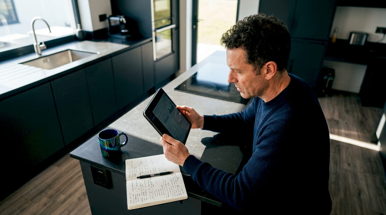 Man reviewing home solar battery data on tablet