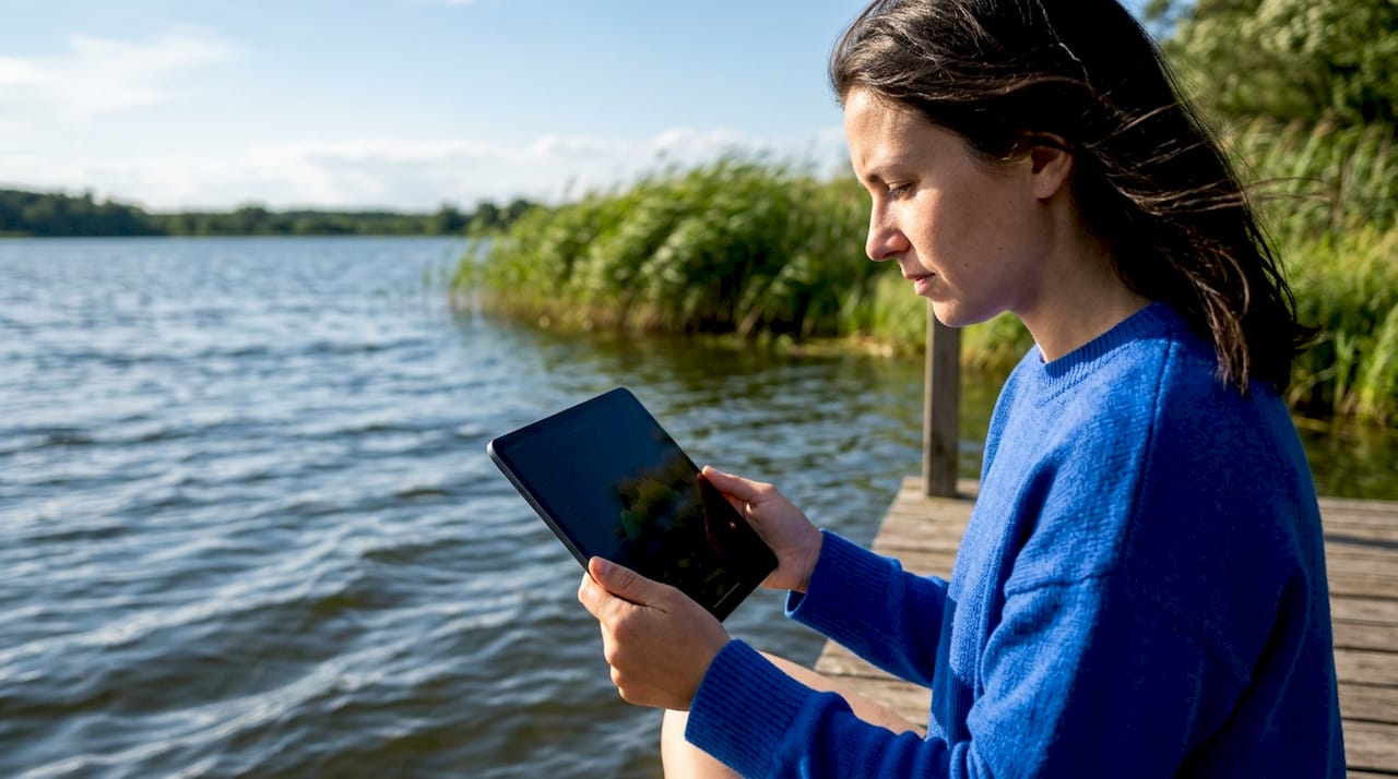 Met een tablet in de hand lekker buiten in het park zitten.