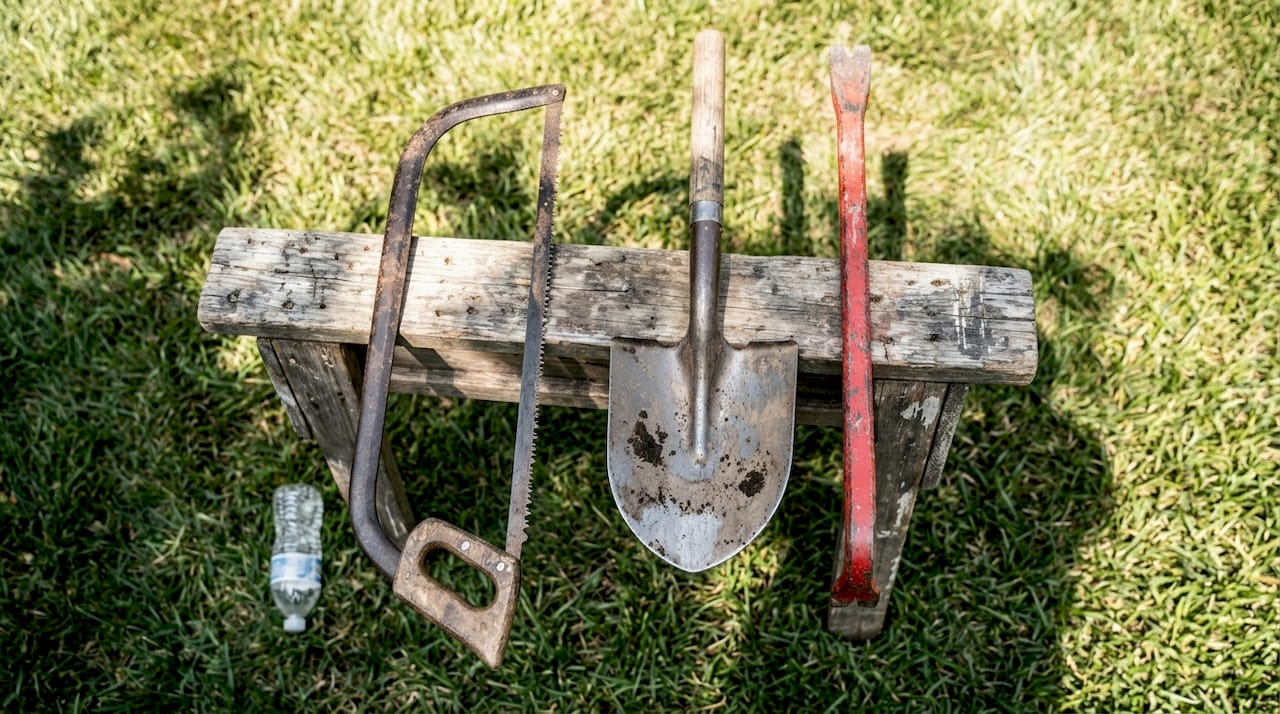 How to remove tree stumps: Central Florida homeowner guide 2 Assorted stump removal tools on backyard sawhorse