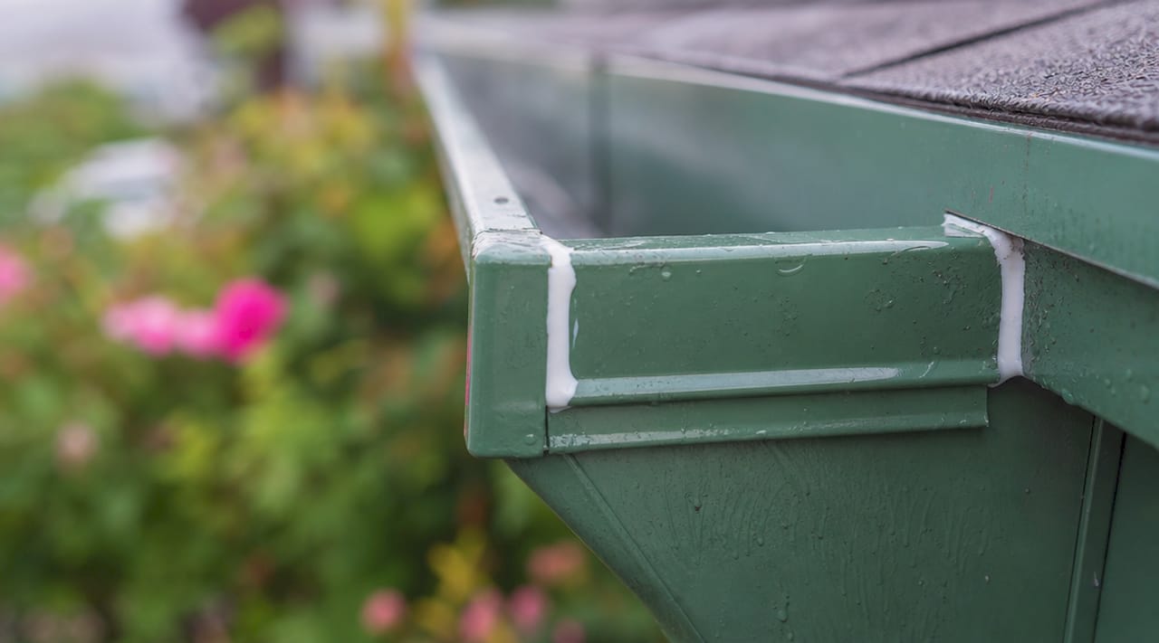 Close-up of sealed gutter corner seam caulking