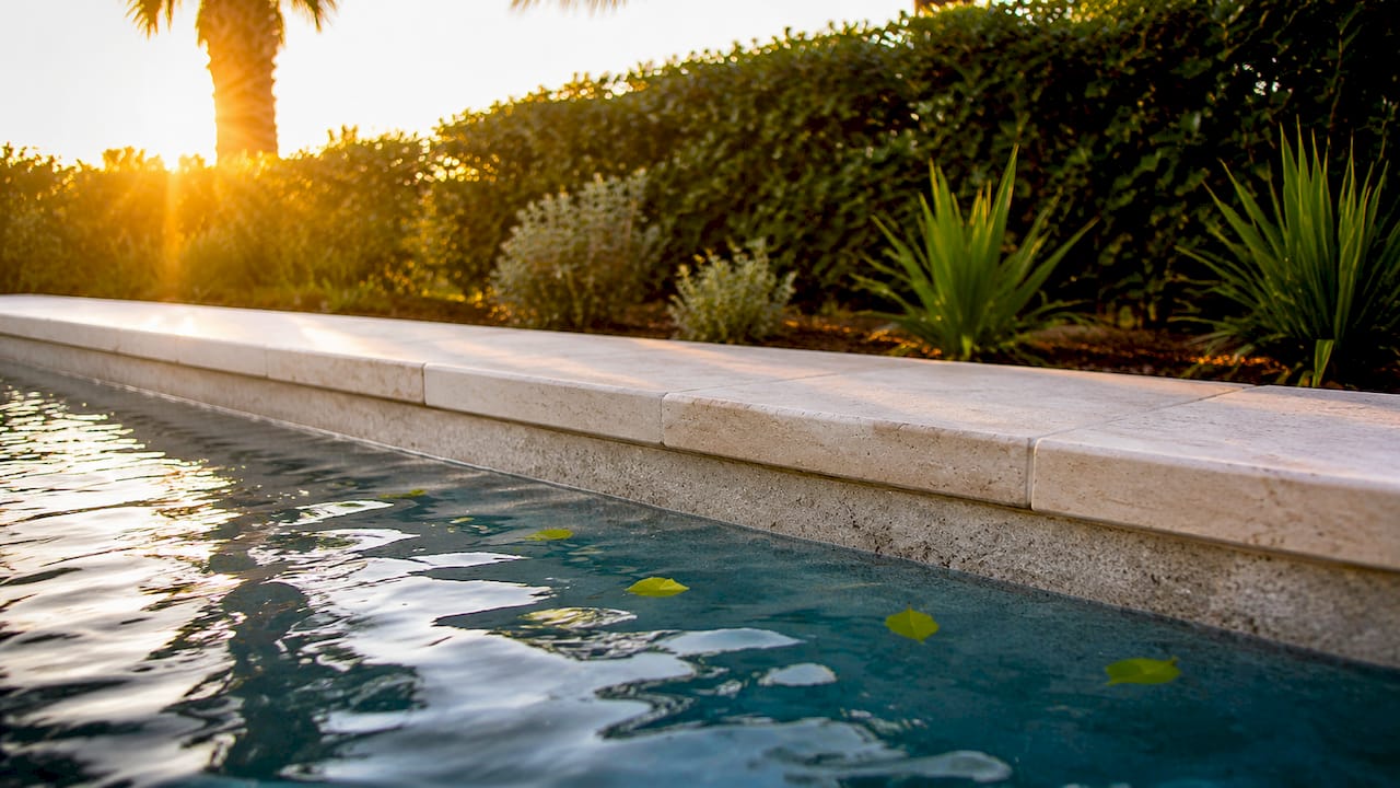 Close-up pool coping cap on concrete bond beam
