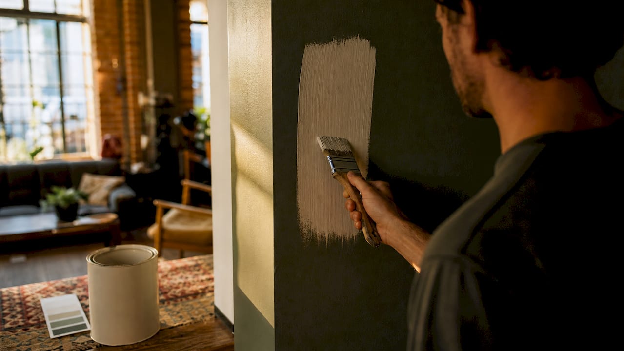 Close-up of brush applying tinted primer on wall
