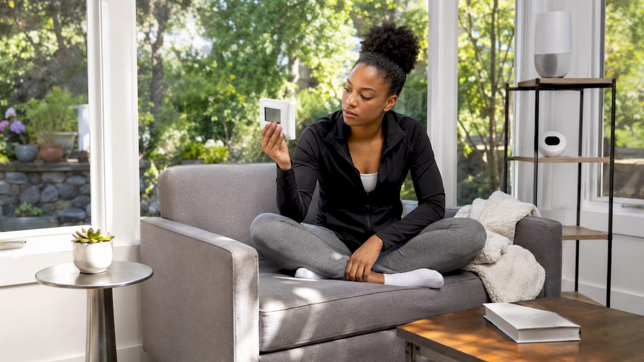 Woman adjusting home ventilation controls indoors