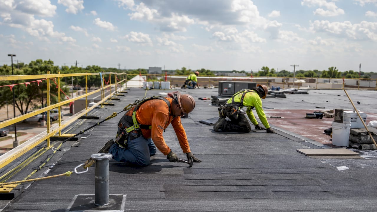 Commercial roofing workers with OSHA fall protection