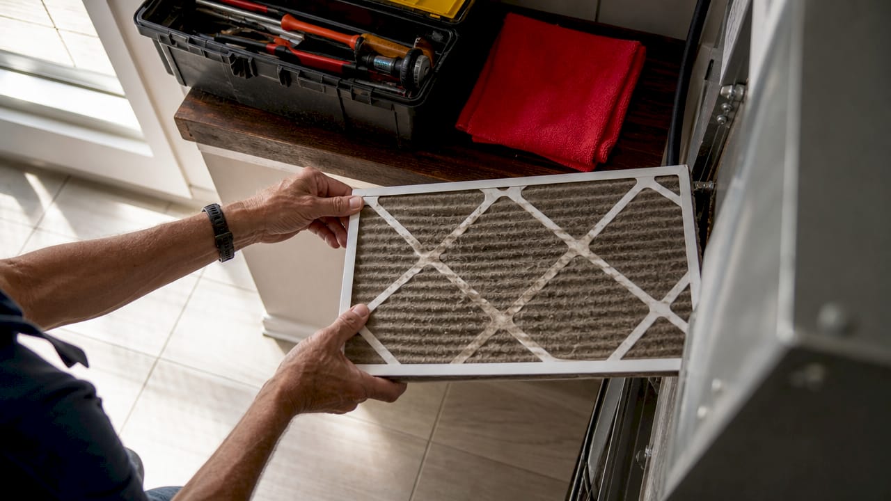 Hands changing dirty air filter