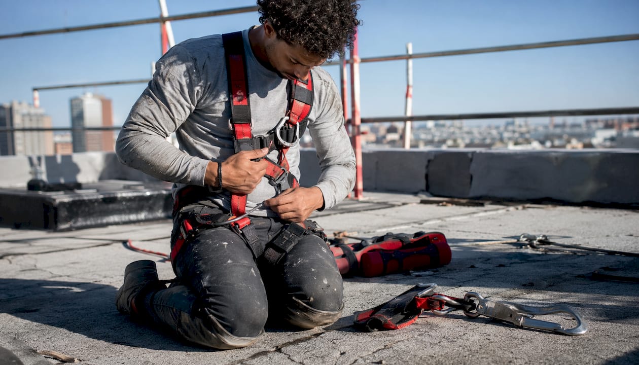 Hands adjusting fall protection harness strap