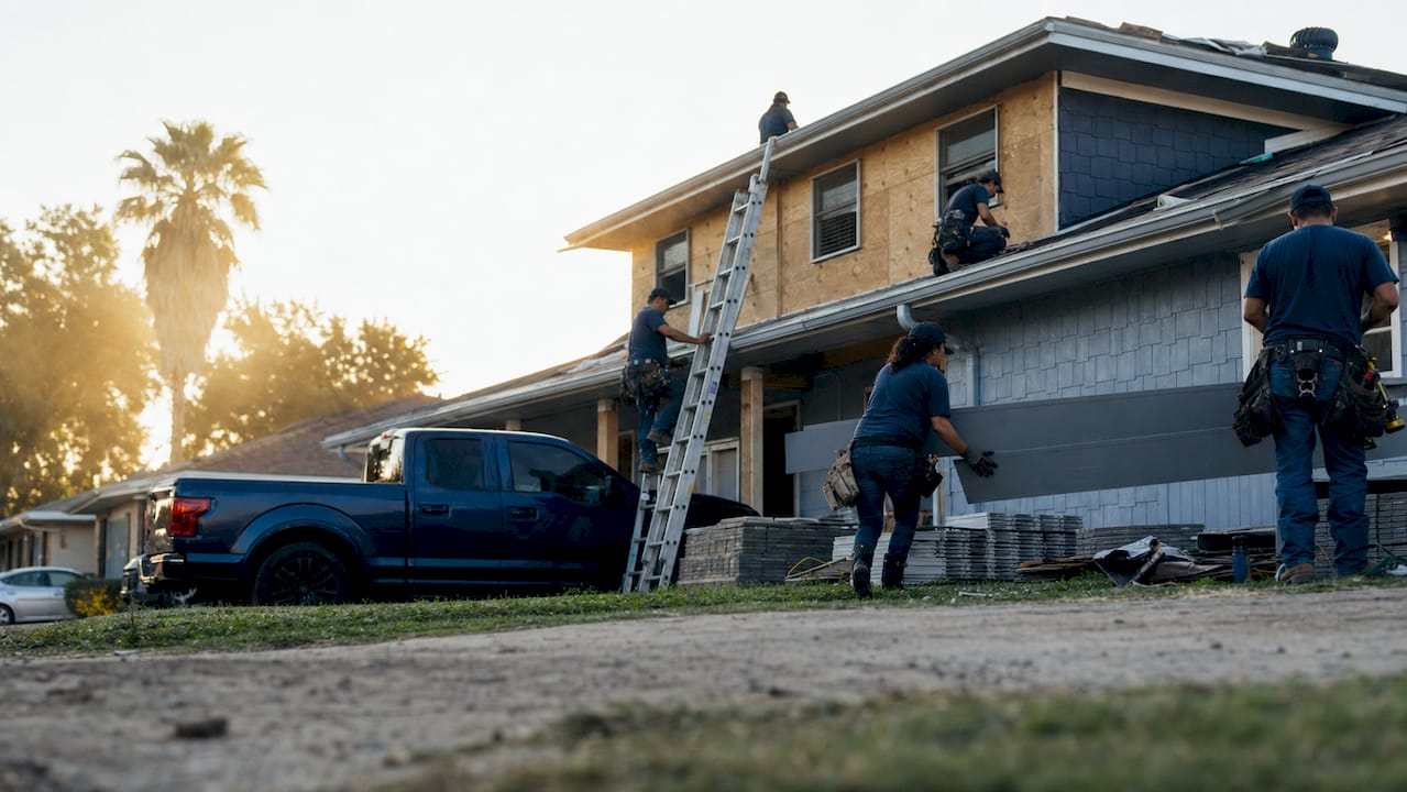 Exterior renovation crew installing roof and siding