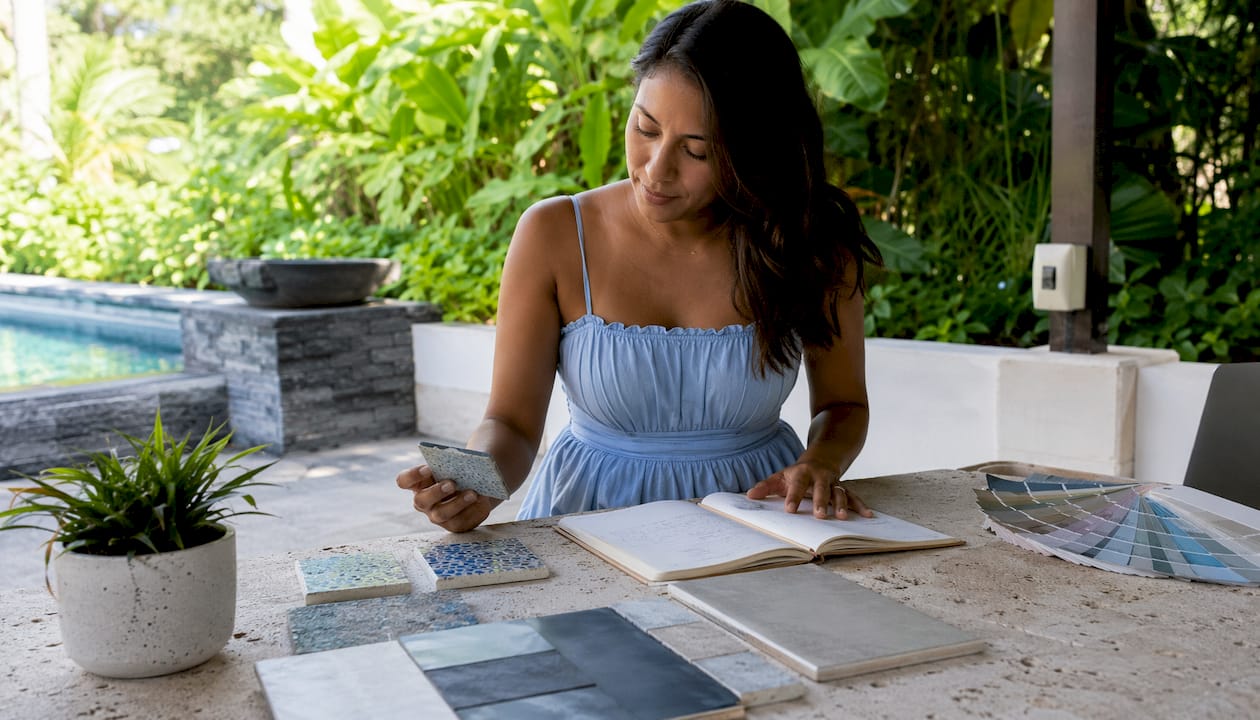Pool designer examines finish samples indoors
