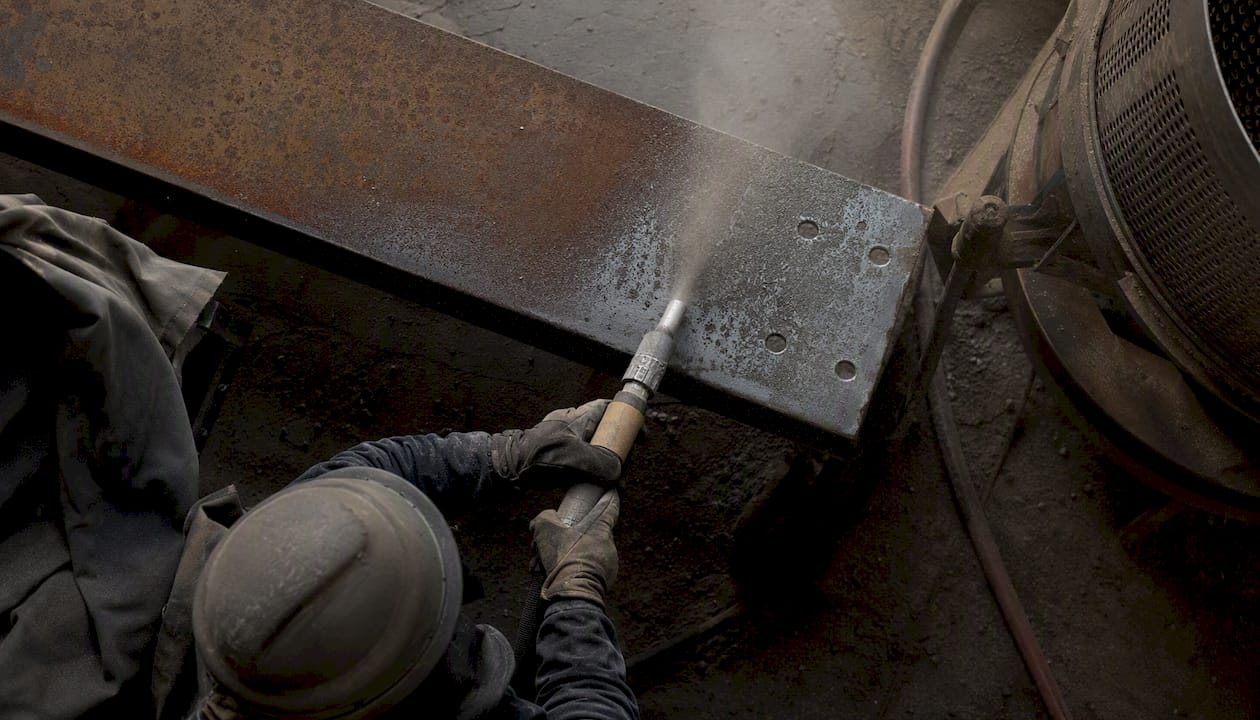 Technician performing close-up industrial sandblasting