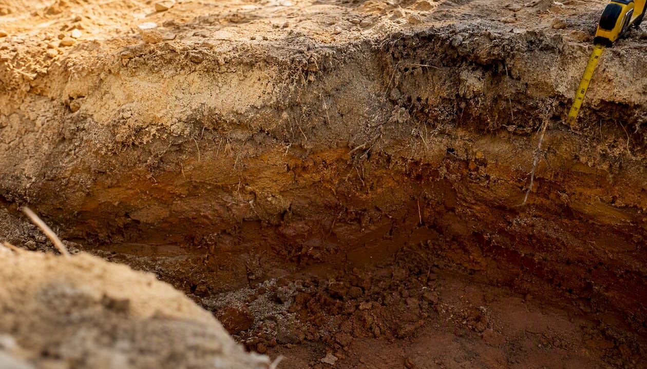 Best spacecoastpoolbuilders.com Alternatives in Central Florida 1 Close-up of sandy and clay soil layers at pool excavation