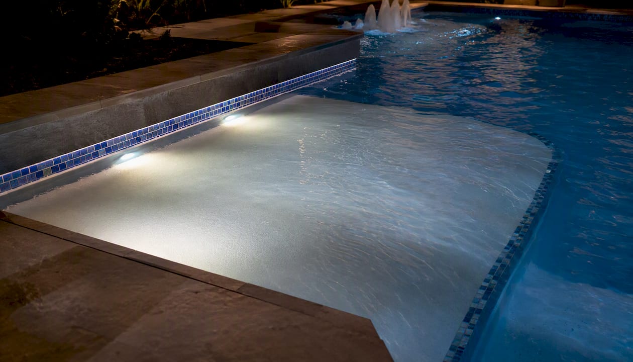 Tanning Ledge Ideas for a Stylish, Functional Pool 2 Tanning ledge glowing with LED lights at night