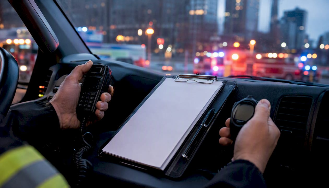 Hands operating radio and stopwatch on incident log