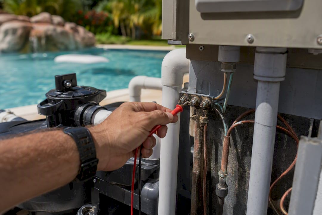 Technician testing pool bonding continuity with multimeter