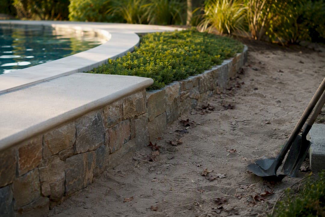 Can You Build a Pool in Sandy Soil? Yes, With the Right Engineering 2 Retaining wall and ground cover stabilizing sandy soil near pool deck