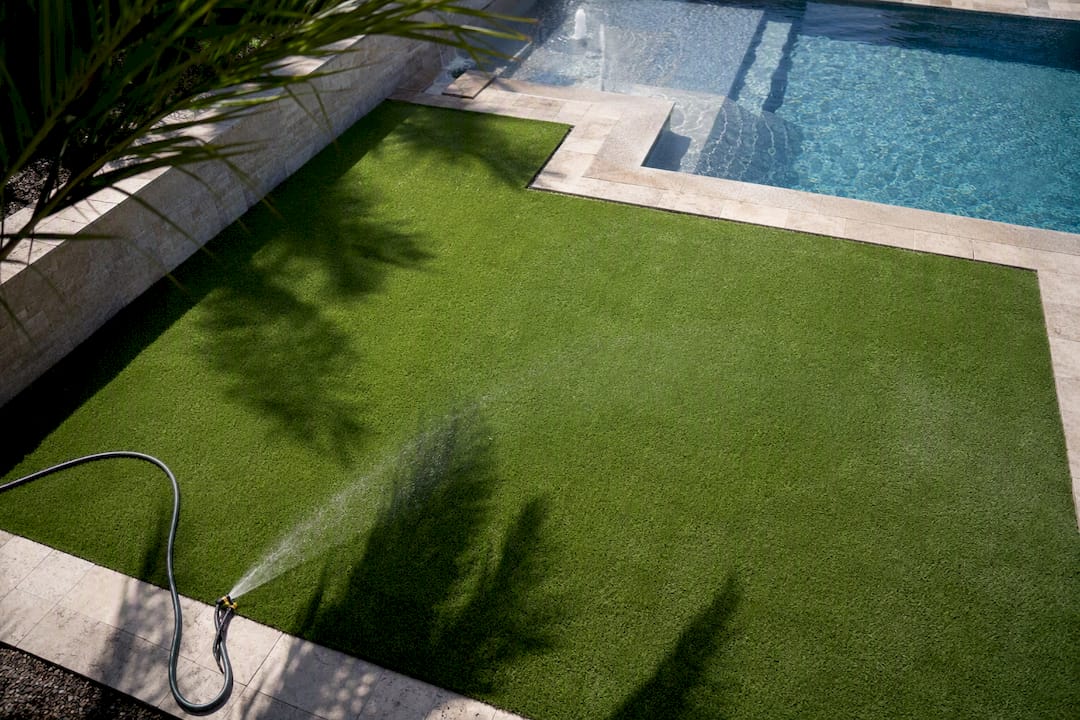 Light-colored synthetic turf cooling by mist near pool