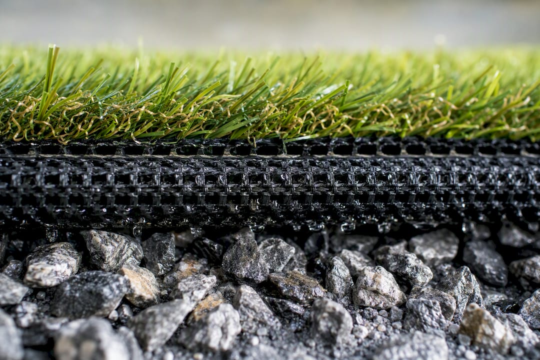 Close-up of drainage layers under poolside synthetic turf
