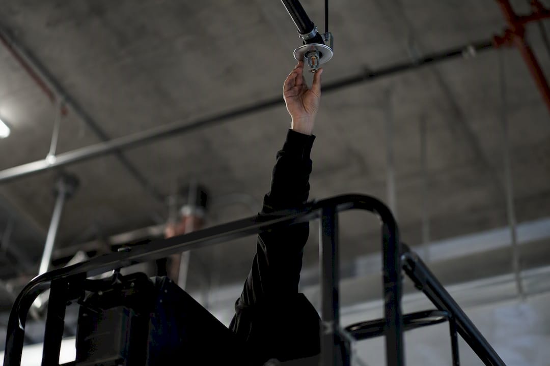 Worker accessing high sprinkler head with lift