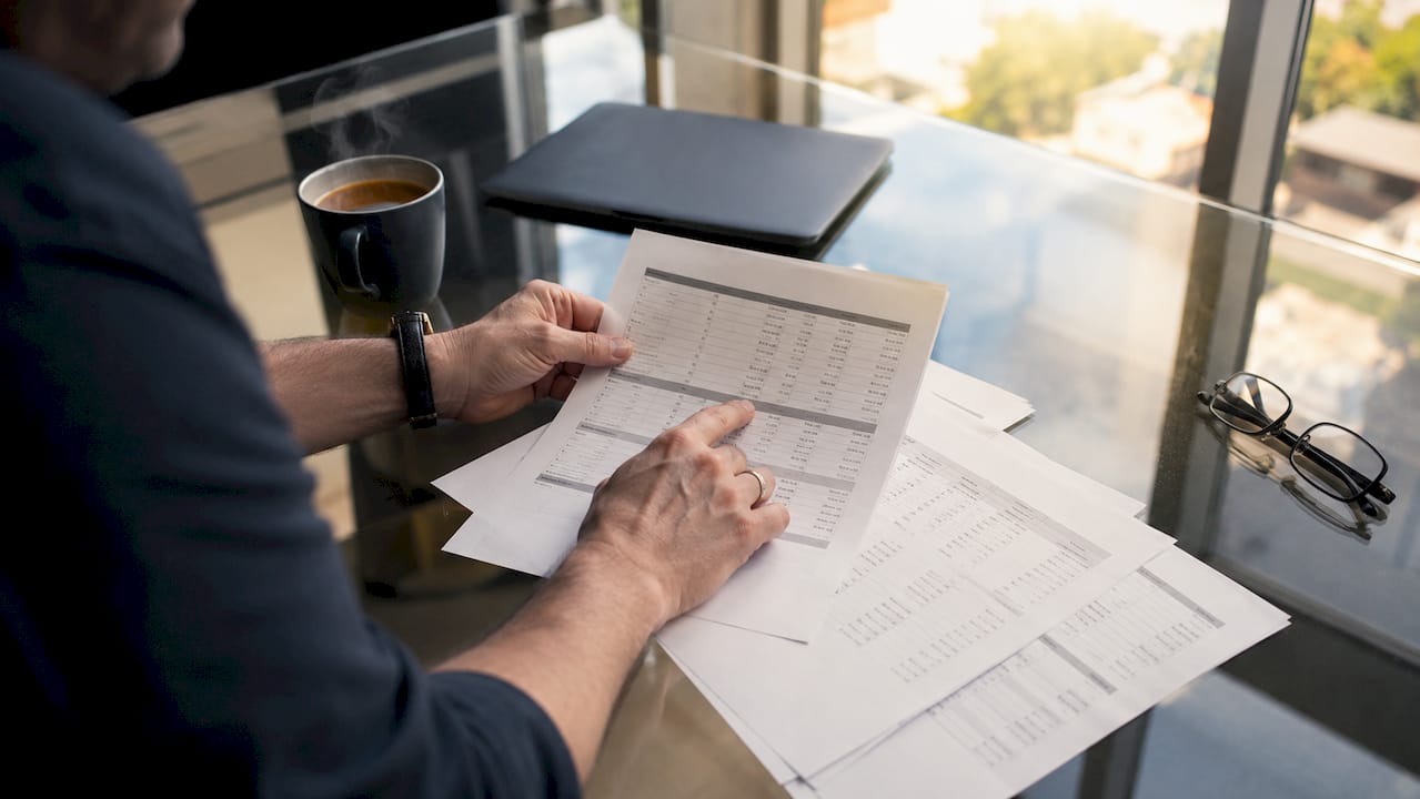 Hands reviewing POS sales and invoice reports