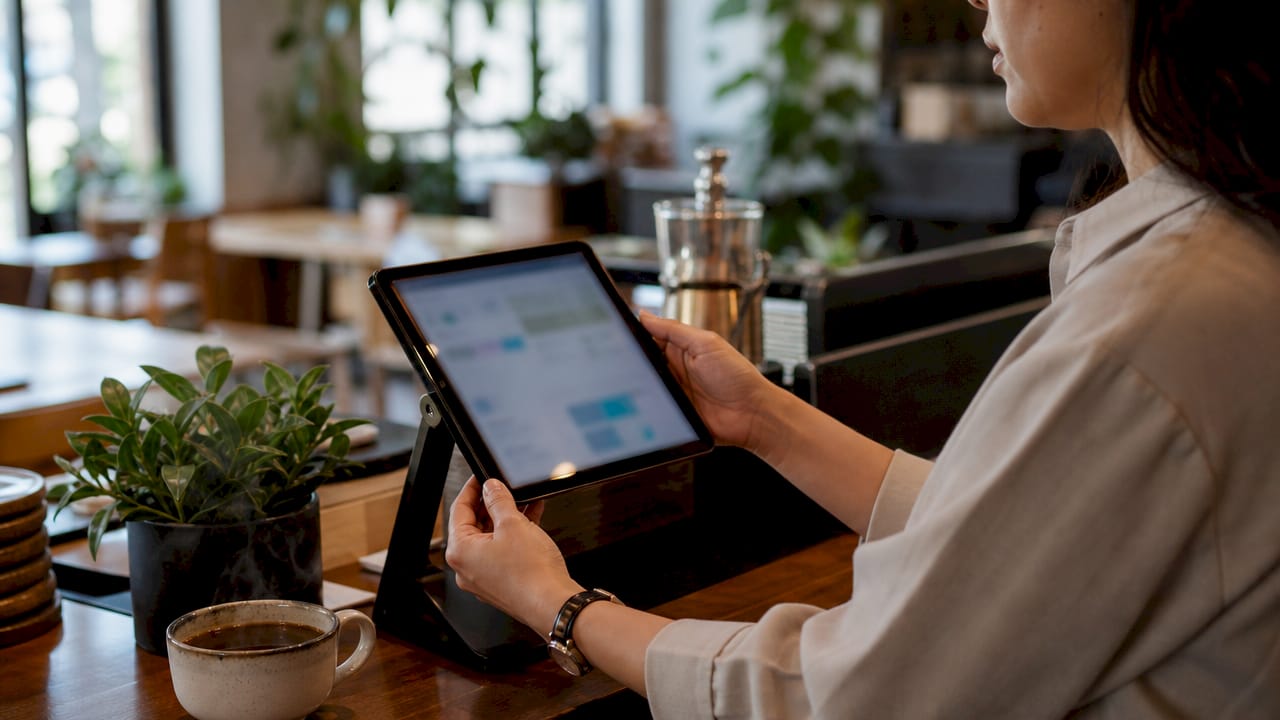 Retail manager using cloud POS tablet in boutique