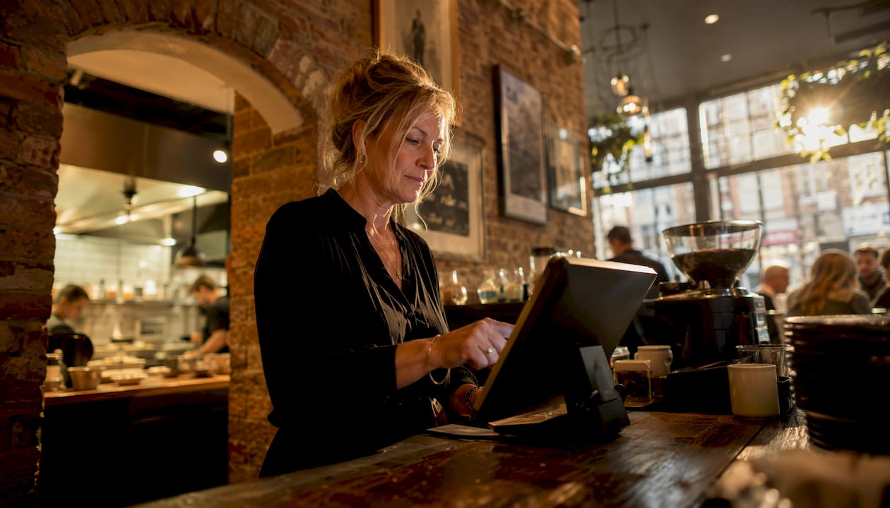 Manager using POS system in UK cafe