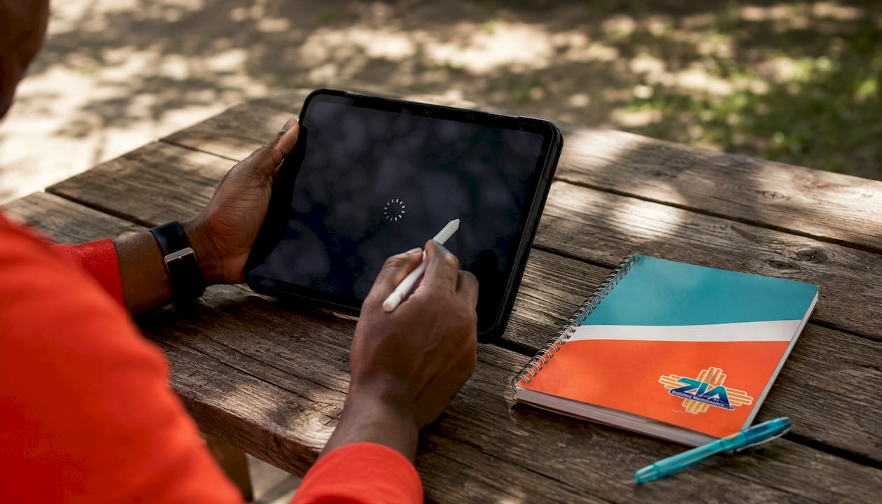 Hands holding stylus over tablet for janitorial app