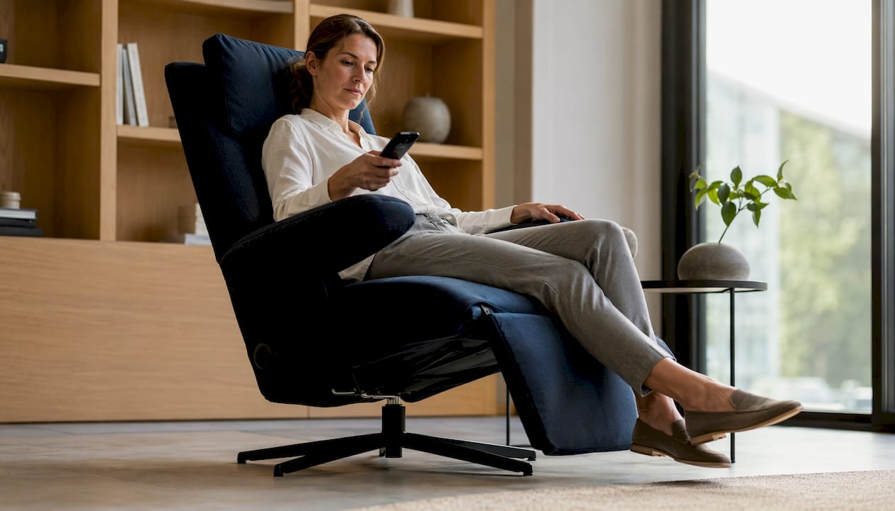 Een vrouw probeert een elektrische relaxstoel uit in de showroom.