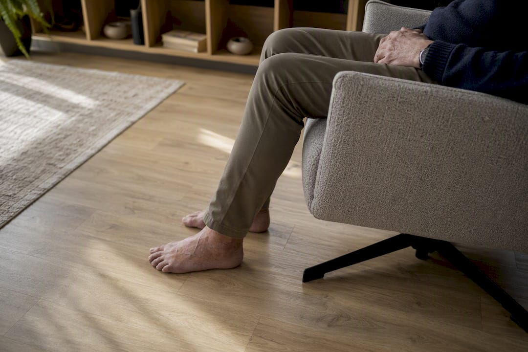 Voeten van een oudere die de vloer raken vanuit een relaxstoel