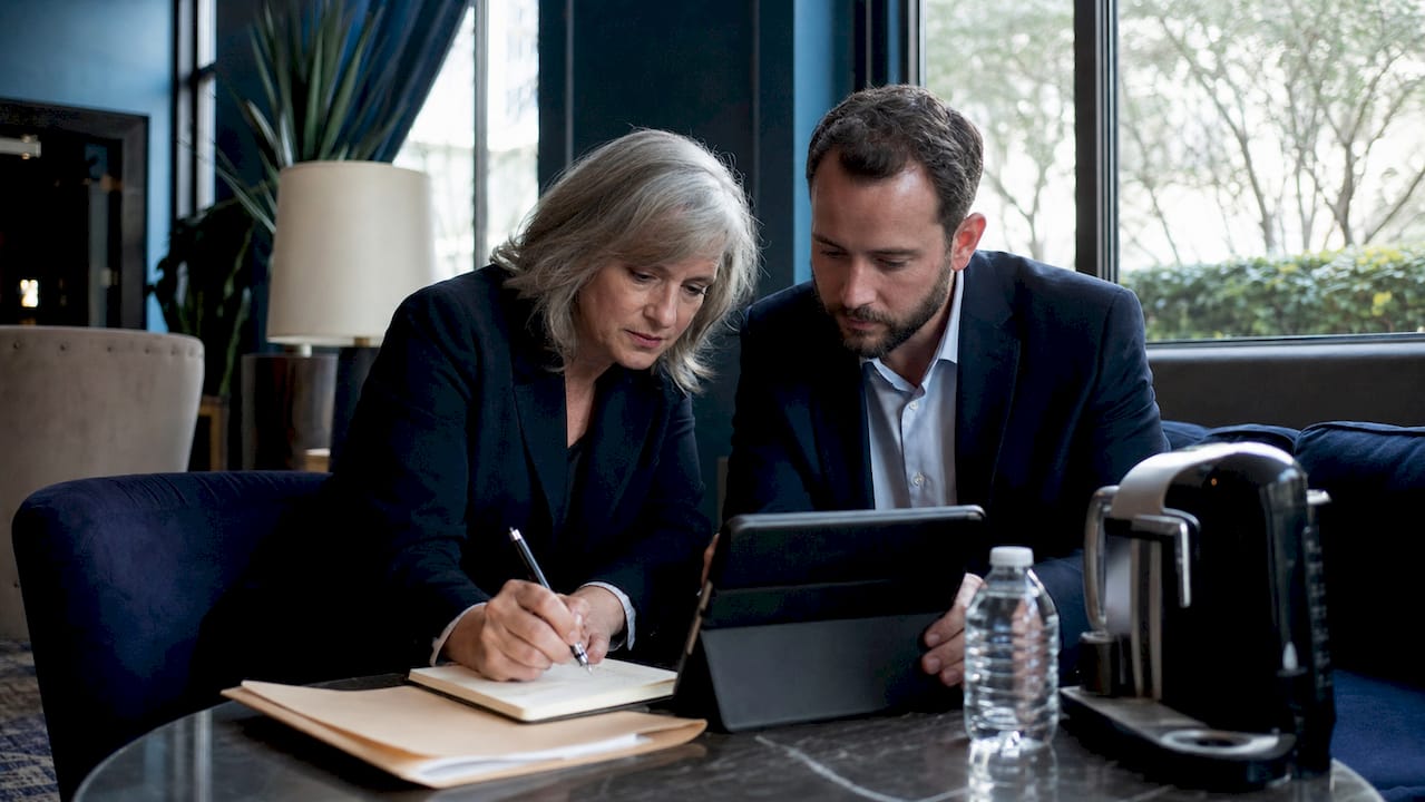 Dos peritos repasando papeles durante una reunión de trabajo