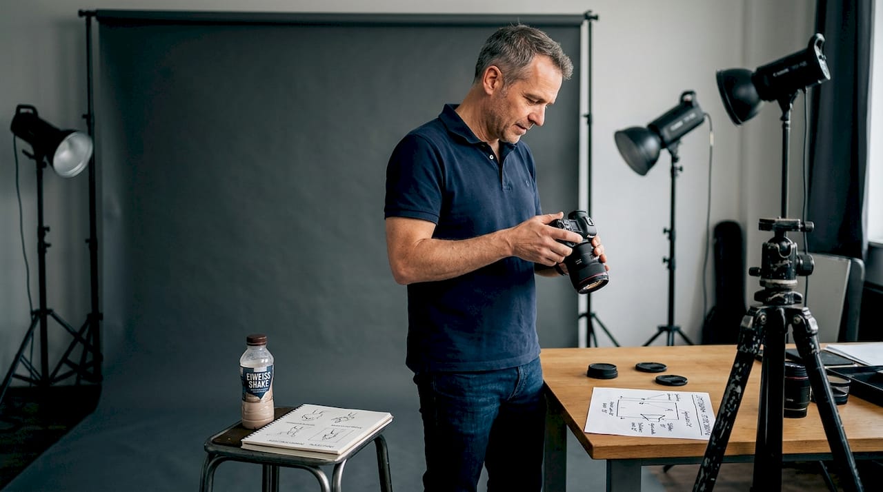 Fotograf überprüft die Lichtverhältnisse beim Shooting im Fitnessstudio