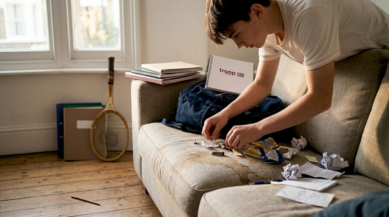 Student cleaning out messy backpack items