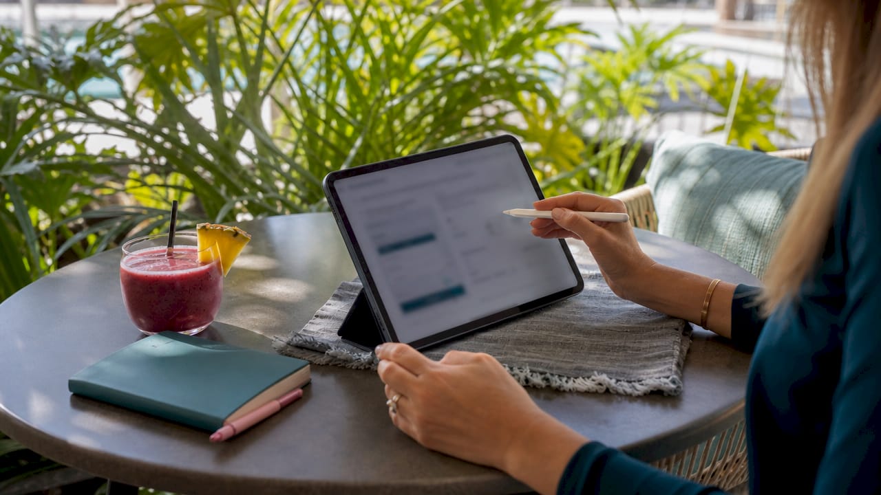 Hands using tablet with leasing app on kitchen table